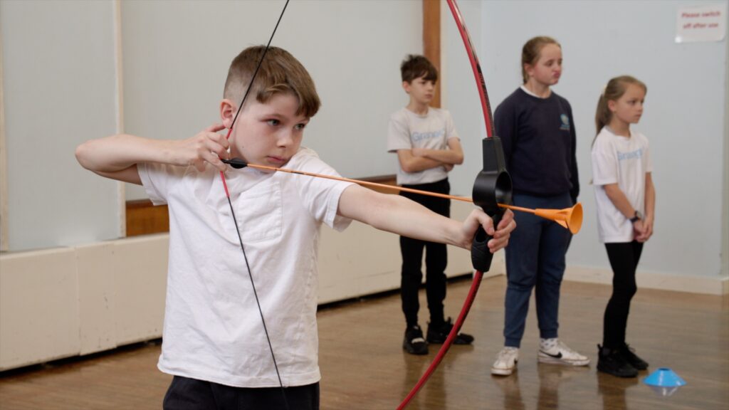 Pupil at Grange Primary School in Shrewsbury doing archery during a PE lesson